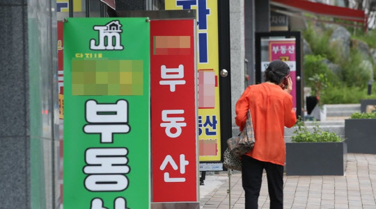 한 시민이 부동산공인중개업소 앞에서 전화를 하고 있다.<연합뉴스>